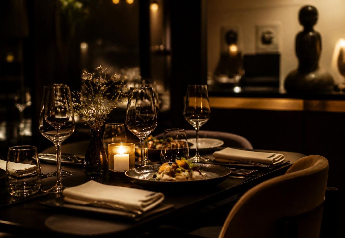 Table dressée dans une salle de restaurant, verres à vin alignés.